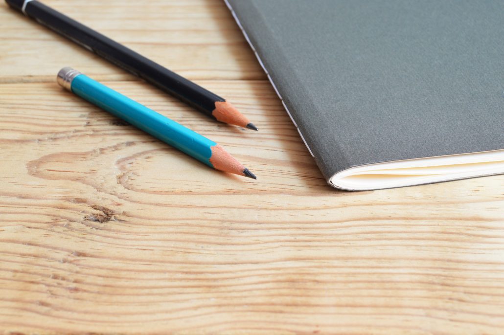 Pencils and copybook on a desk